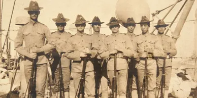Historic group of early U.S. Marines standing in formation with rifles during training period photograph